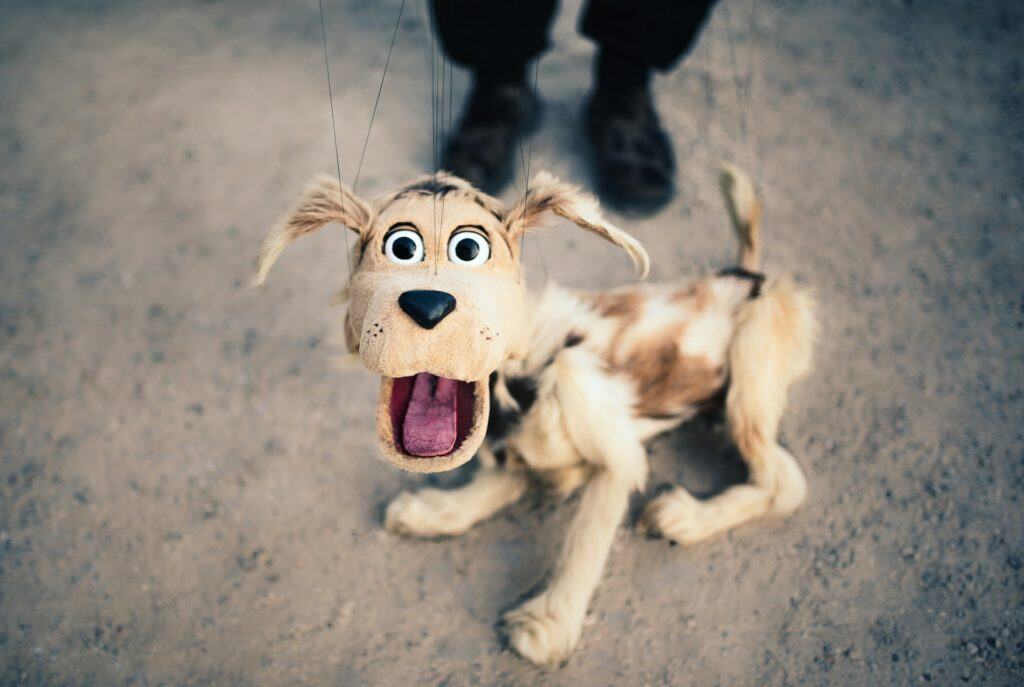 A photograph of a cute dog marionette puppet.