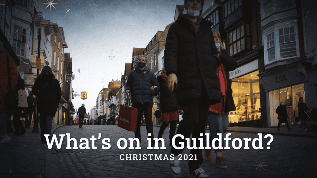 Text reading What's on in Guildford? Christmas 2021 is overlaid onto a low angle shot of Guildford high street with a starry navy vignette