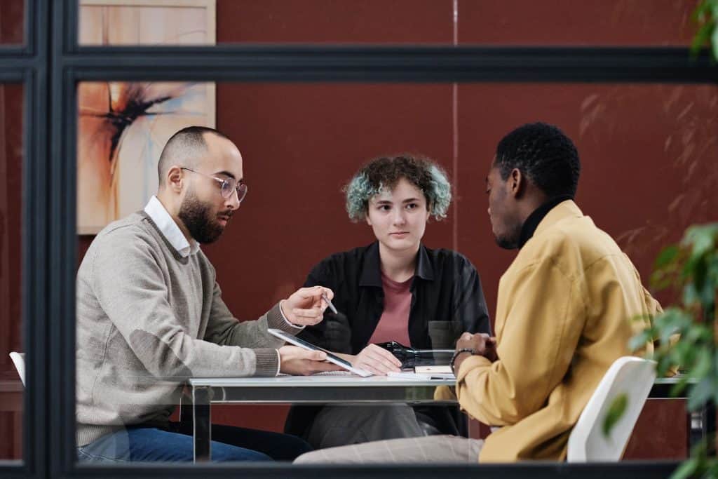 Three people sitting around discussing a budget