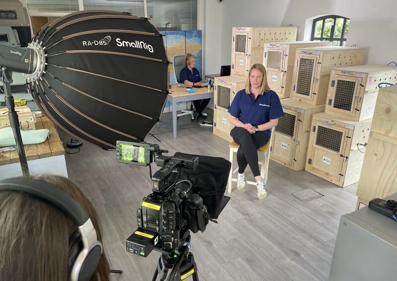 Behind the camera shot of an interview showing the light, camera and subject