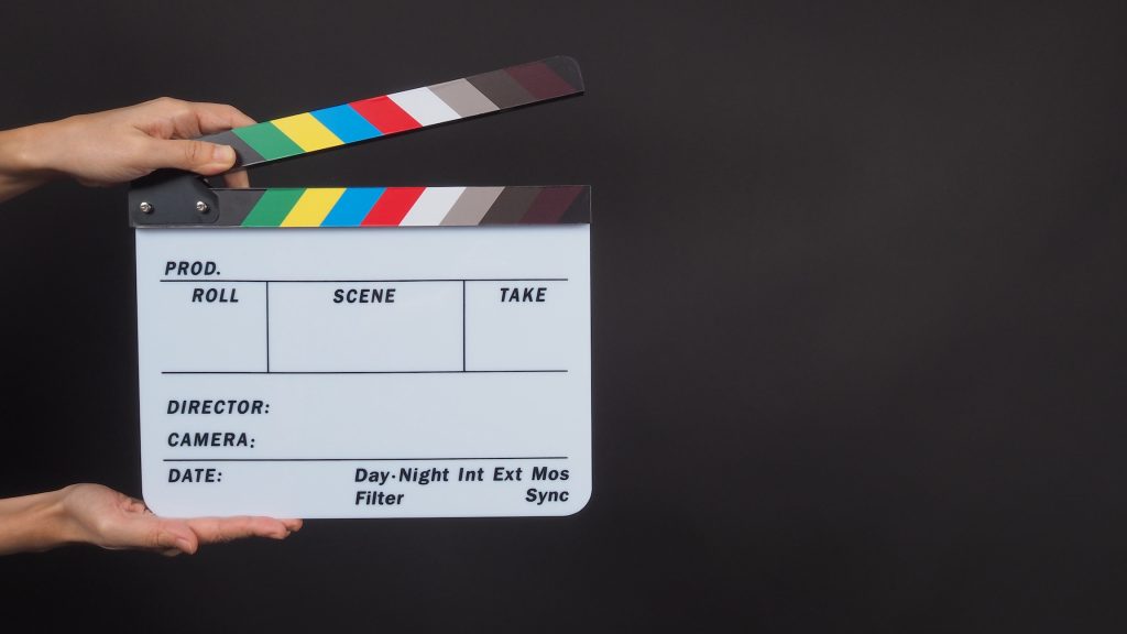 hands-is-holding-clapperboard-on-black-background