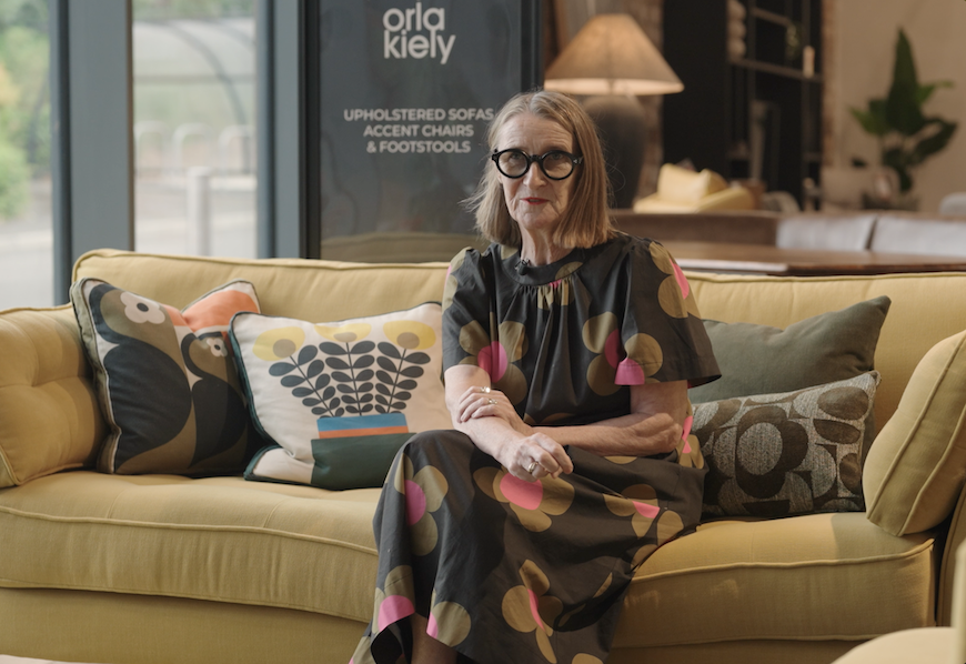 Orla Kiely sat on a sofa from her new collection in the Barker and Stonehouse showroom