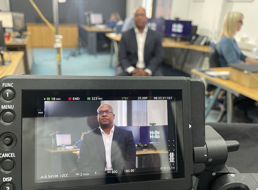 Shot of Tim Hatari through the camera and in shot