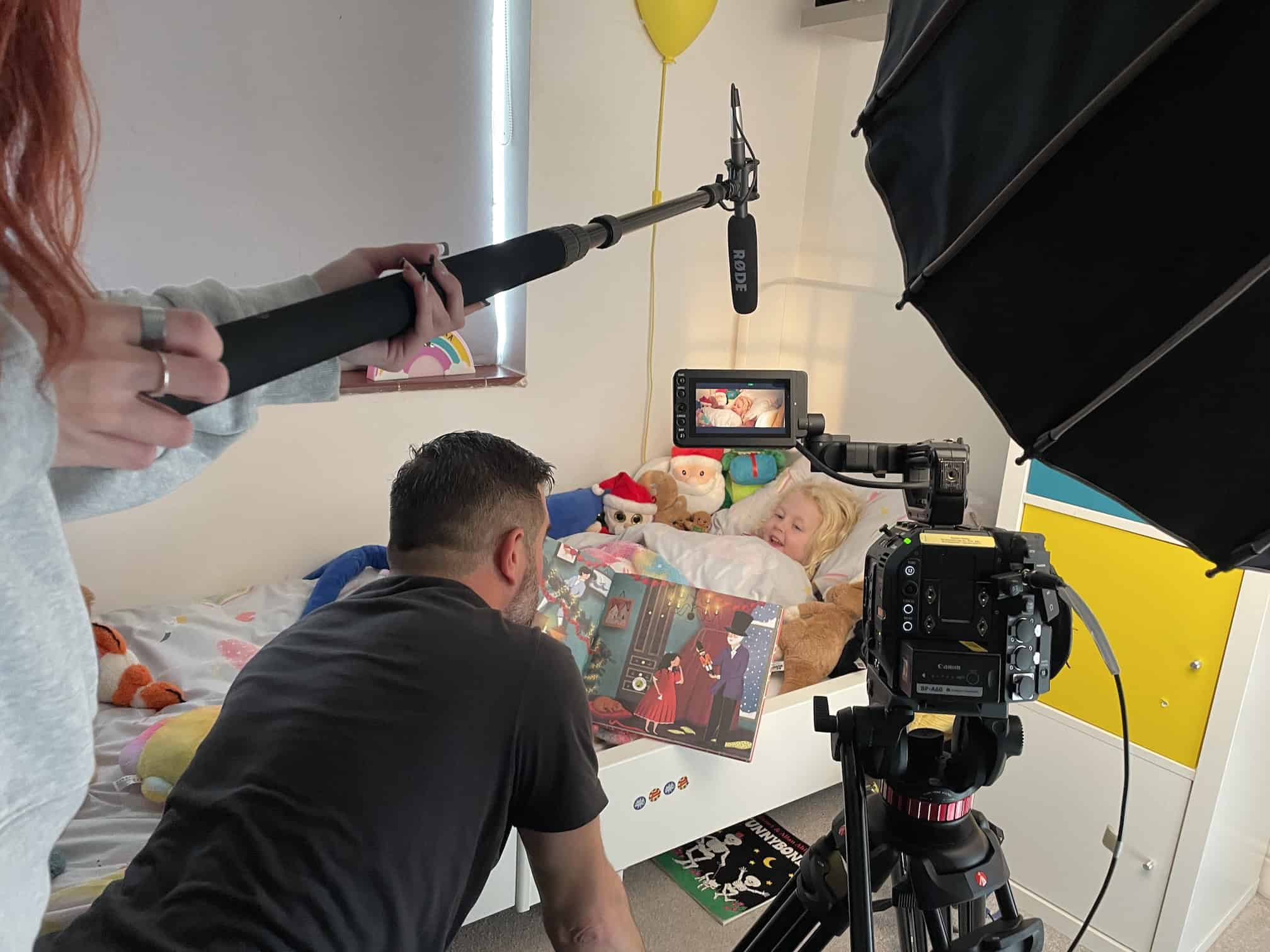 Shot of a crew filming a young actor in a bedroom setting